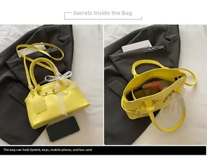 Detail view of yellow shell bag interior showing spacious main compartment and lace bow