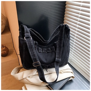 Dettaglio della borsa tote in denim nero con cuciture a contrasto e tasche funzionali