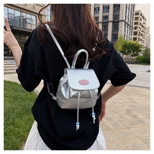 Mini-Rucksack in Silbermetallic mit rosa Label und Kordelzug in der Trageansicht