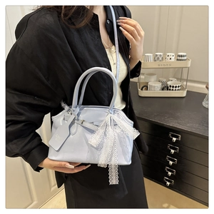 Light blue faux leather handbag featuring a delicate white lace bow accessory