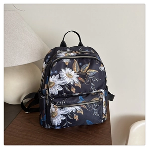 Detail view of floral backpack with white daisy patterns and multi-pocket storage design