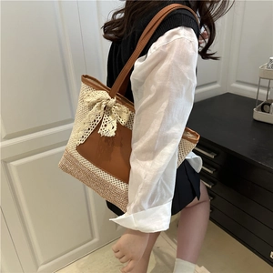 Handmade woven straw tote bag with lace bow and tan leather handles for beach vacation