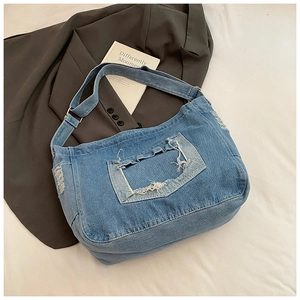 Dettaglio macro del tessuto denim lavato con bordi sfilacciati e texture della borsa