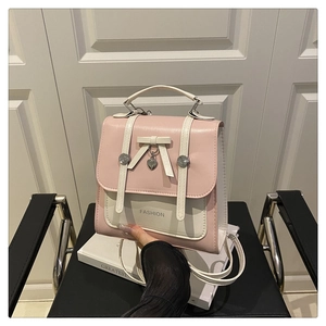 Detailed view of pink bow backpack with silver heart charm and FASHION lettering
