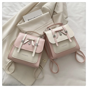 Detailed view of fashion mini backpacks with heart charm and bow on soft fabric