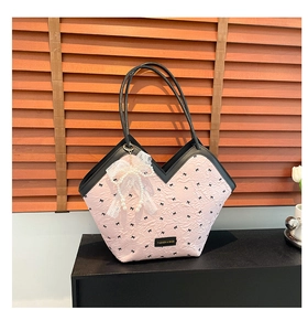 Close-up of pink tote bag featuring black bow embroidery and delicate lace pearl pendant
