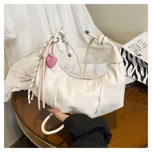Détail du sac nuage plissé blanc cassé avec breloque cœur rose et logo fashion gaufré