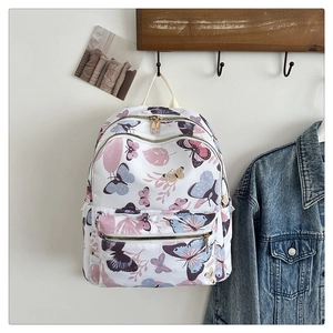 Detail of floral butterfly print backpack hanging on a hook in a warm home setting