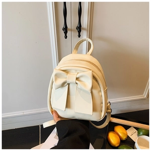 Close-up of creamy white PU leather mini backpack featuring a large bow and gold zipper