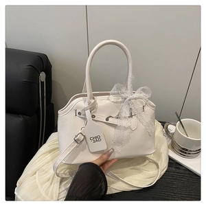 Detailed shot of white Boston bag featuring lace bow decoration and silver metal hardware