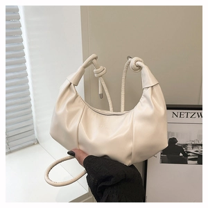 Détail du sac nuage plissé crème avec poignée nouée et logo de mode embossé