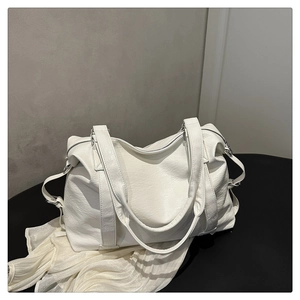 Détail d'un grand sac cabas blanc texturé avec foulard en soie et boucles argentées
