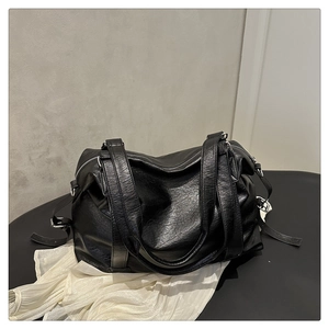 Détail du sac cabas en cuir noir avec ferrures argentées et texture grainée douce