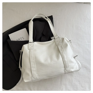 Détail du sac cabas blanc en cuir texturé avec boucle métallique sur le côté