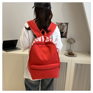 Detailed view of lightweight red nylon school backpack with white OWILE print for students