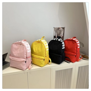 Detailed view of casual nylon backpacks in pink, yellow, black and red colors