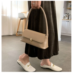 Détail d'un sac baguette en similicuir kaki avec un fermoir à pression en métal doré