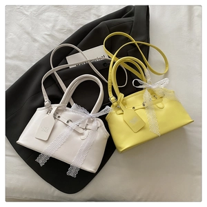 Close-up of leather handbags featuring delicate lace bows and signature brand tags