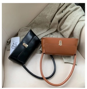 Détail de sacs sous les aisselles minimalistes français en noir et marron avec fermoir doré