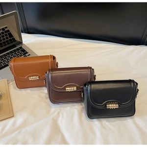 Detailed view of flap crossbody bags in brown, coffee, and black with gold metal locks
