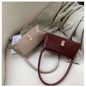 Vue détaillée des sacs d'aisselle en cuir lisse avec fermoirs dorés en beige et rouge foncé