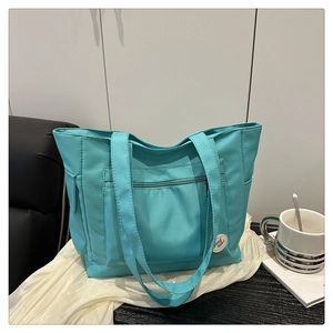 Turquoise canvas tote bag for commute displayed with a white coffee mug on a desk