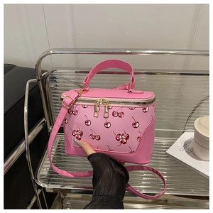 Detailed view of pink cherry print box bag with golden zippers and detachable strap