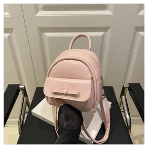 Detail view of mini pink PU backpack featuring a chic bow and metallic zipper closure