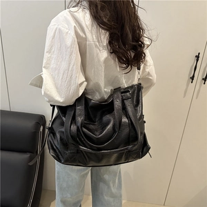 Chic black oversized faux leather tote bag for travel with soft pleated texture