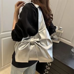 Silver metallic tote bag with large bow detail shown on shoulder for a stylish look