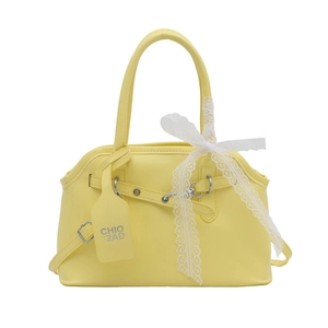 Light yellow faux leather handbag with lace bow and adjustable crossbody strap