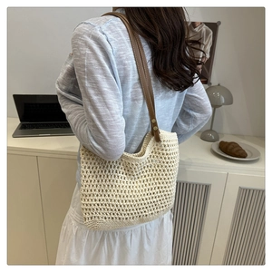 Detail der cremefarbenen Häkeltasche mit Netzstruktur und braunem Leder-Schultergurt