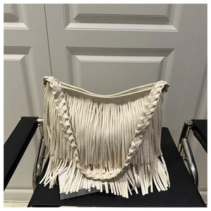 Détail du sac à bandoulière blanc avec franges denses et bandoulière tressée chic