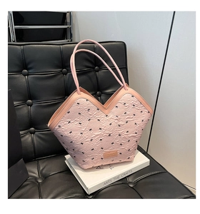 Detail of pink tote bag with V-shaped opening and mini black bow print pattern