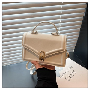 Détail du sac à main blanc crème avec fermoir doré ovale et texture cuir élégante
