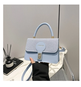 Dettaglio della texture in pelle PU blu chiaro e tessuto saia su una borsa a tracolla