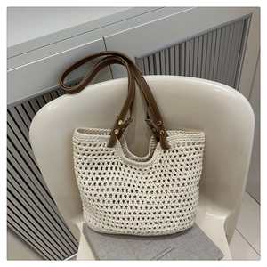 Detail der gehäkelten Baumwolltasche mit braunen Ledergriffen und goldenen Nieten