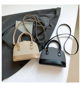 Detail of woven straw-style shell bags in beige and grey with smooth leather trim