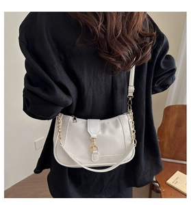 Minimalist beige crescent shoulder bag with gold chain and metal buckle on casual model