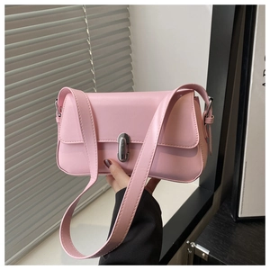 Detail of pink shoulder bag with silver oval metal twist lock and premium stitching