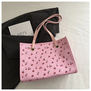 Dettaglio della borsa rosa con stampa ciliegia, occhielli in metallo e tracolla