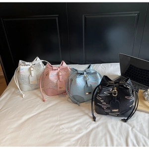 Detail of four colorful drawstring bucket bags with wave embroidery and metal buckles