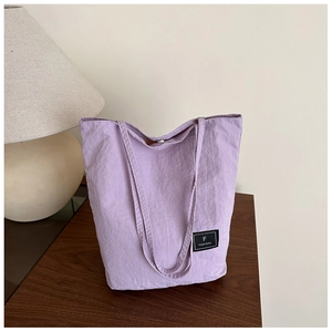 Macro view of light purple canvas tote bag with F FANYISSA brand label on fabric