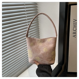 Detail der rosa Canvas-Beuteltasche mit gelbem Blumendruck und glattem Schultergurt