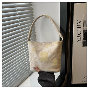 Detail der Blumenstruktur auf beiger Schultertasche mit Jacquard-Blumenmuster