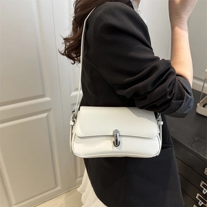 Minimalist white leather shoulder bag with sleek silver buckle on female model