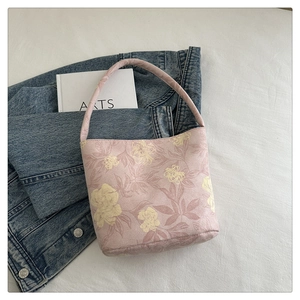 Detail der rosa Leinentasche mit Blumenmuster auf einer blauen Jeansjacke