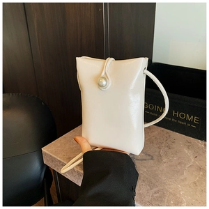 Detailed view of the white crossbody phone bag featuring a large pearl clasp and PU leather