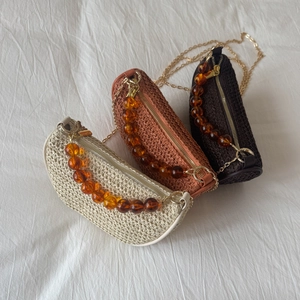 Handwoven straw shoulder bag with amber chain handle in off-white, brown and coffee colors