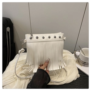 Detail of white PU leather crossbody bag featuring fringe tassels and silver metal studs